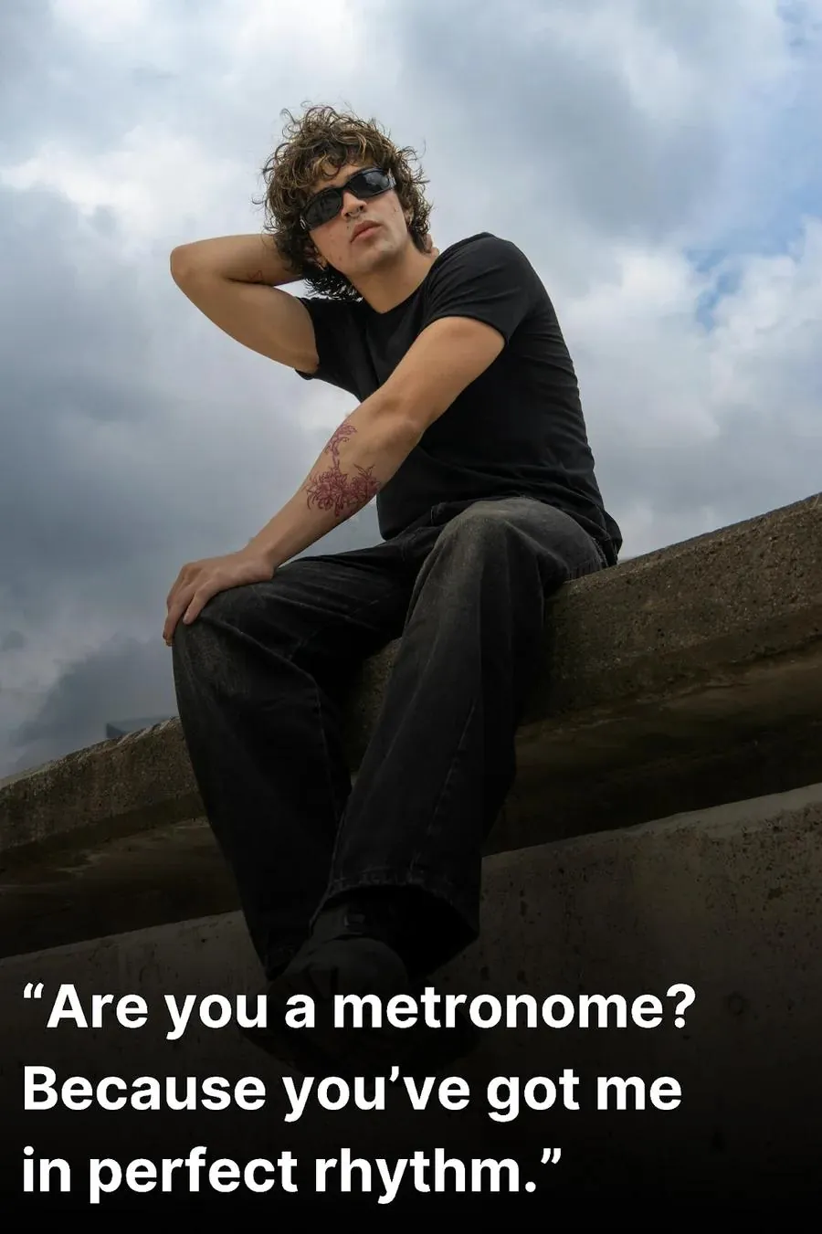 Cool-looking young man sitting on a wall while waiting for the best pick up line